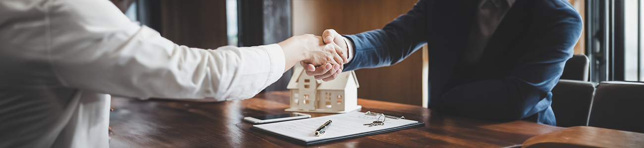 Real estate agent and customer shaking hands after contract completion